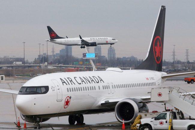 FILE PHOTO: An Air Canada Boeing 737 MAX 8 from San Francisco approaches for landing at Toronto Pearson International Airport over a parked Air Canada Boeing 737 MAX 8 aircraft in Toronto